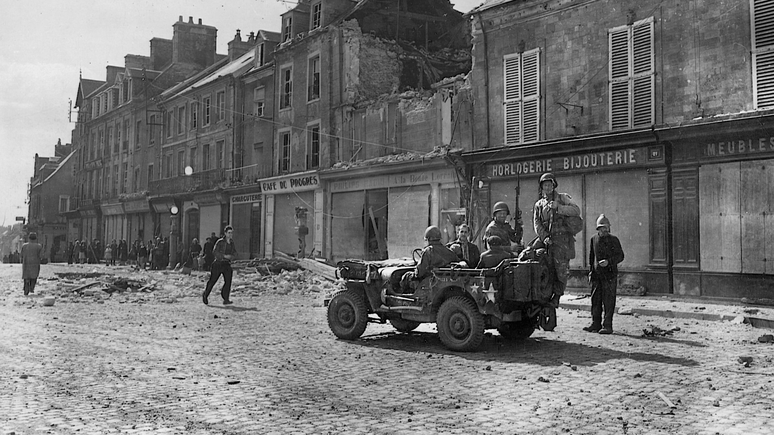 Several of them arriving aboard a jeep, troopers of the 101st Airborne Division enter the important Norman town of Carentan on June 14, 1944. The fighting at Carentan was heavy, and the Americans withstood several German counterattacks.