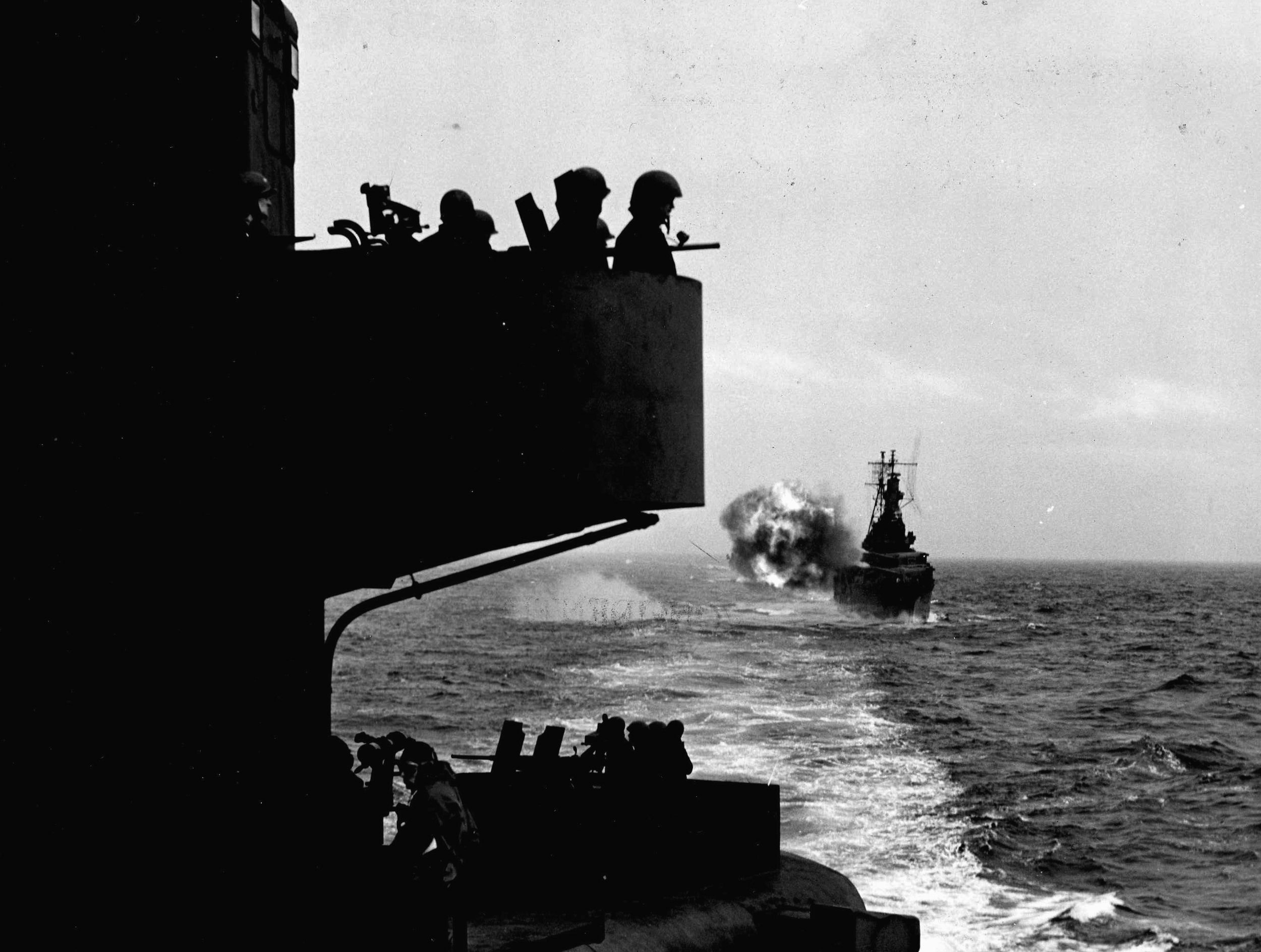 A salvo from the cruiser USS Indianapolis is loosed against reported Japanese positions on Kiska. During the intense prelanding shelling of the island, the Indianapolis was on station astern of the cruiser USS Salt Lake City, from which this photograph was taken. 
