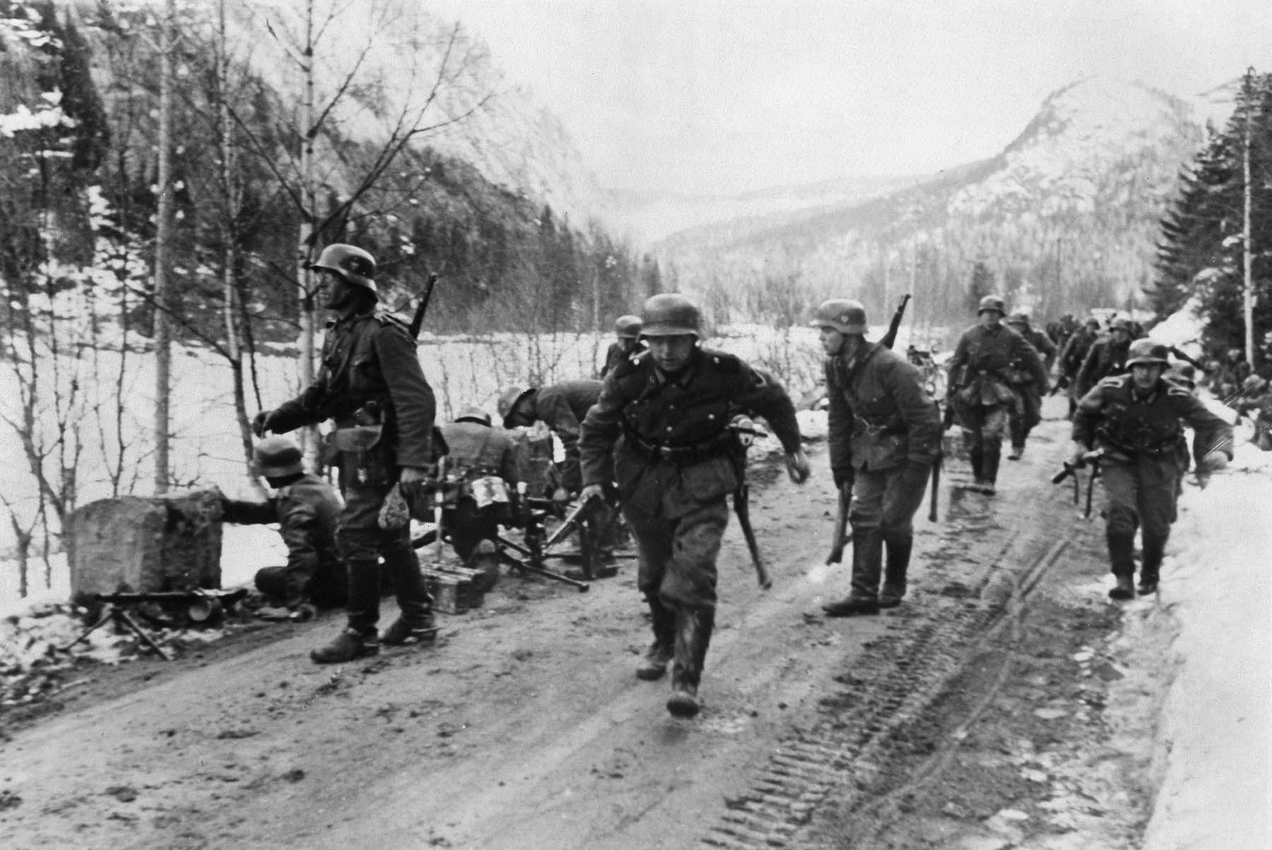 Wary of potential resistance, German sol- diers advance cautiously along a Norwegian road in April 1940. The Germans were somewhat surprised by the tenacity of the Norwegian troops who defended their country.
 