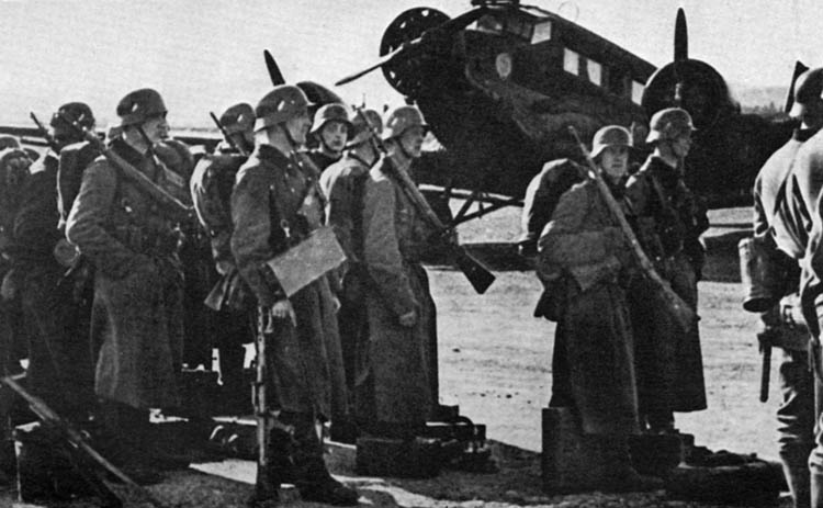 Their Ju-52 aircraft in the background, German infantrymen just airlifted to Norway prepare to march toward the ongoing fighting.