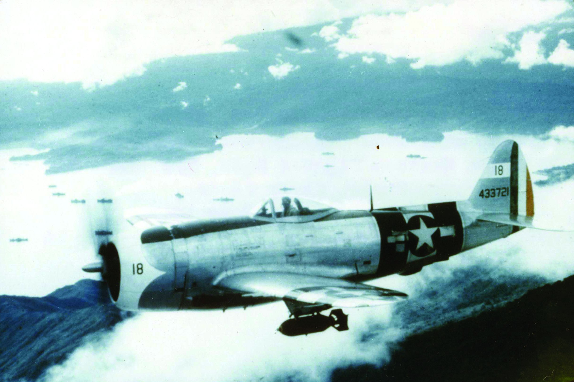 A P-47 of the Mexican 201st Fighter Squadron flies in formation above Clark Field in the Philippine Islands. Note the bomb attached to a hard point beneath the fuselage. (National Archives)