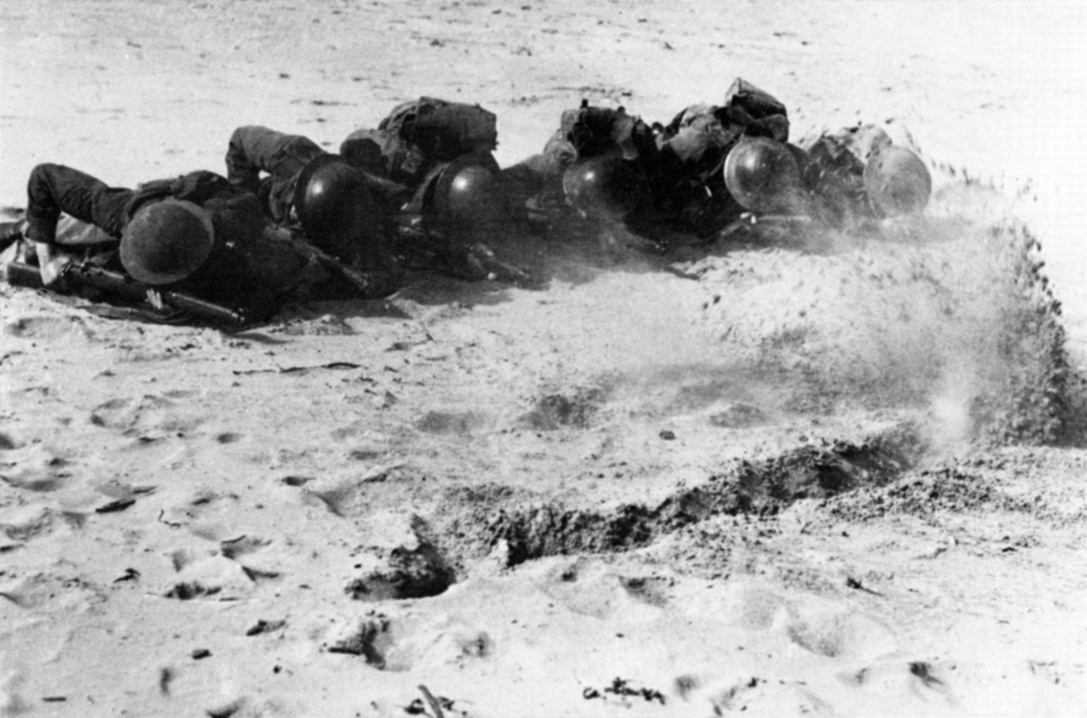 Commandos crawl through bullet-ridden sand during a training exercise at the Commando Training Center at Achnacarry, Scotland. Father Basil first met the Rangers when they arrived at the center in 1942.