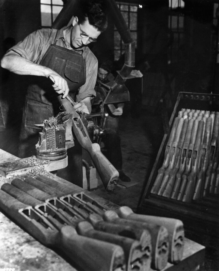 In September 1940, a worker finishes the wooden gunstock of an M-1 Garand rifle. Thousands of M-1s were produced at several sites in the U.S. during World War II.