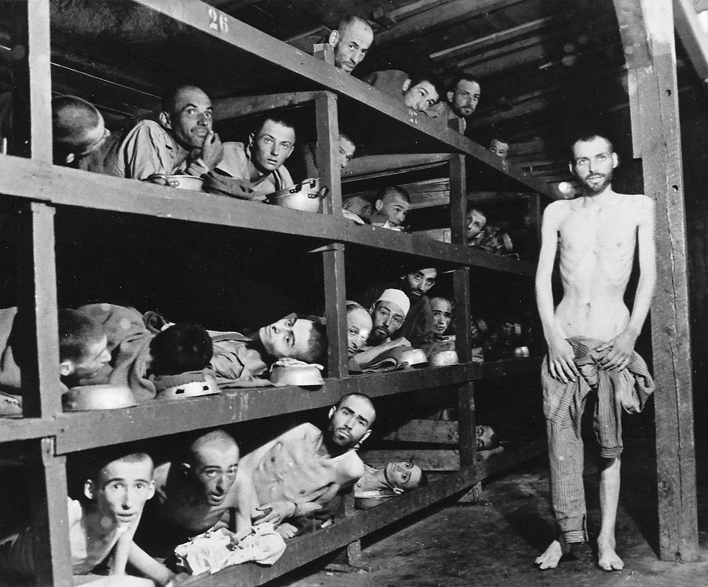 This interior view of a barracks at Buchenwald reveals the stifling confines of the sleeping area. Some of the prisoners use their food bowls as pillows. Disease spread rapidly in such close quarters and accounted for many deaths. (National Archives)