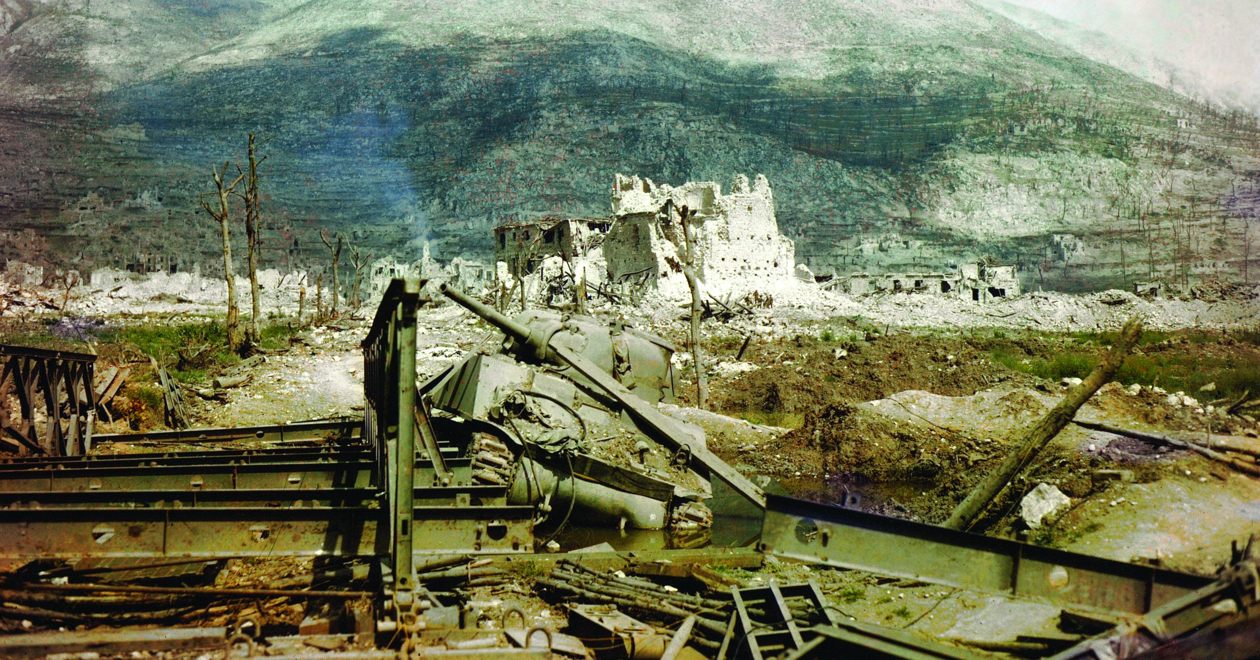The town of cassino is left a shambles in the aftermath of heavy allied bombardment. anchoring the western end of the formidable gustav line, cassino and the benedictine abbey that crowned the adjacent mountaintop proved costly for the allies to capture. the wreckage of a sherman tank and a prefabricated bailey bridge lie in the foreground.