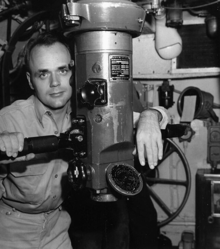 Commander Bladen D. Claggett, skipper of the submarine USS Dace, poses with his periscope aboard the vessel in September 1945. (All photos: National Archives)
