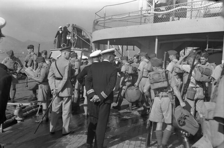 Leaving their troop ship HMCS Prince Robert on November 16, 1941, infantrymen of C Company, Royal Rifles of Canada, are observed by officers. The Canadians had not seen combat and were not listed as ready for such arduous duty. (Above: Imperial War Museum / Left: Library and Archives of Canada)