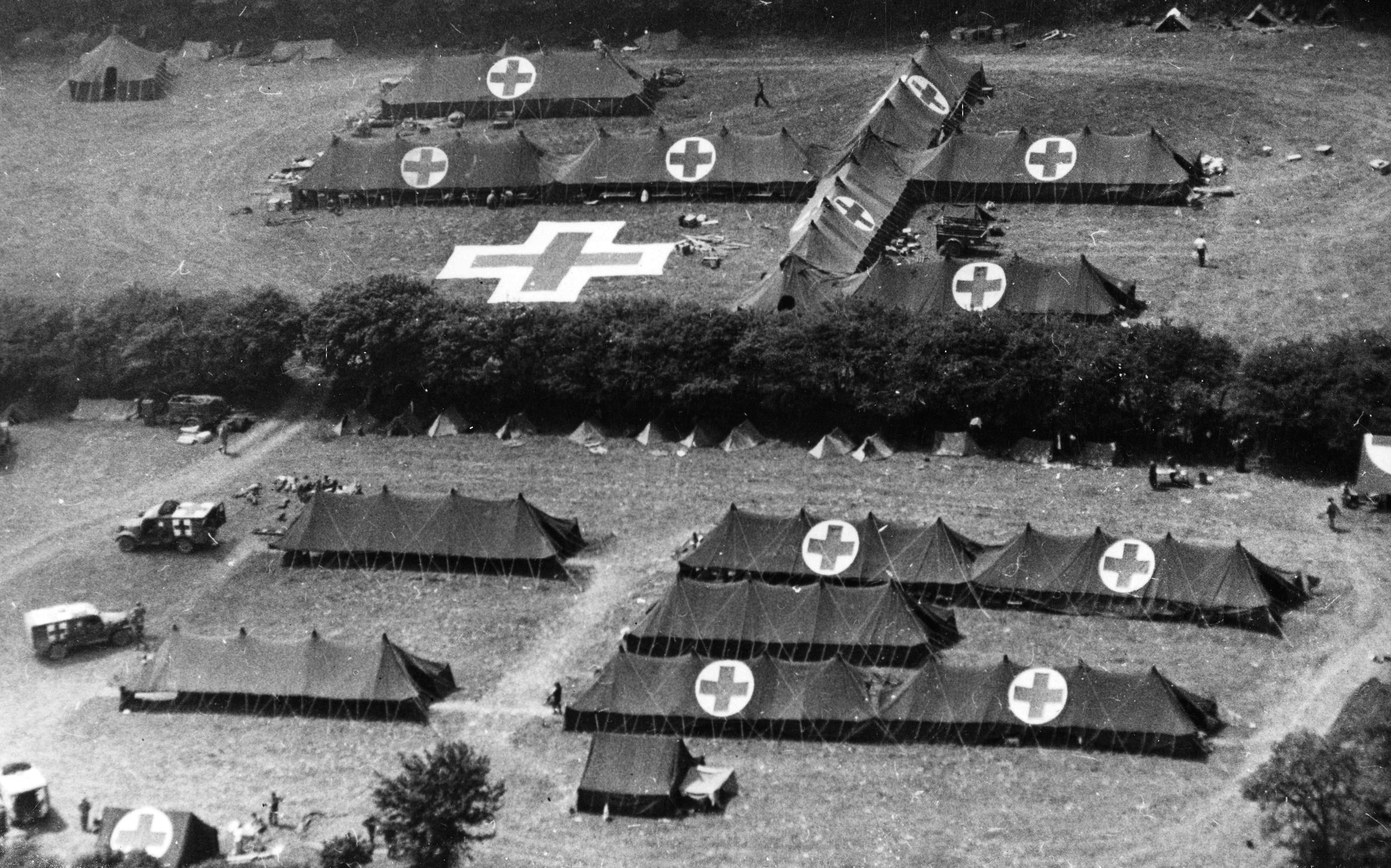 Clearly marked by large red crosses atop its tents, a U.S. Army field hospital has been erected on the Cherbourg Peninsula in France during the summer of 1944. The distinctive markings were placed for easy visual recognition from the air. 