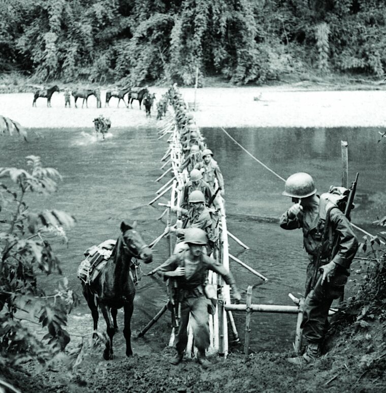 With pack mules in tow, soldiers of the 5307th Composition Unit, dubbed Merrill's Marauders by the press, cross the Chindwin River in Burma on a foot bridge, March 17,1944.