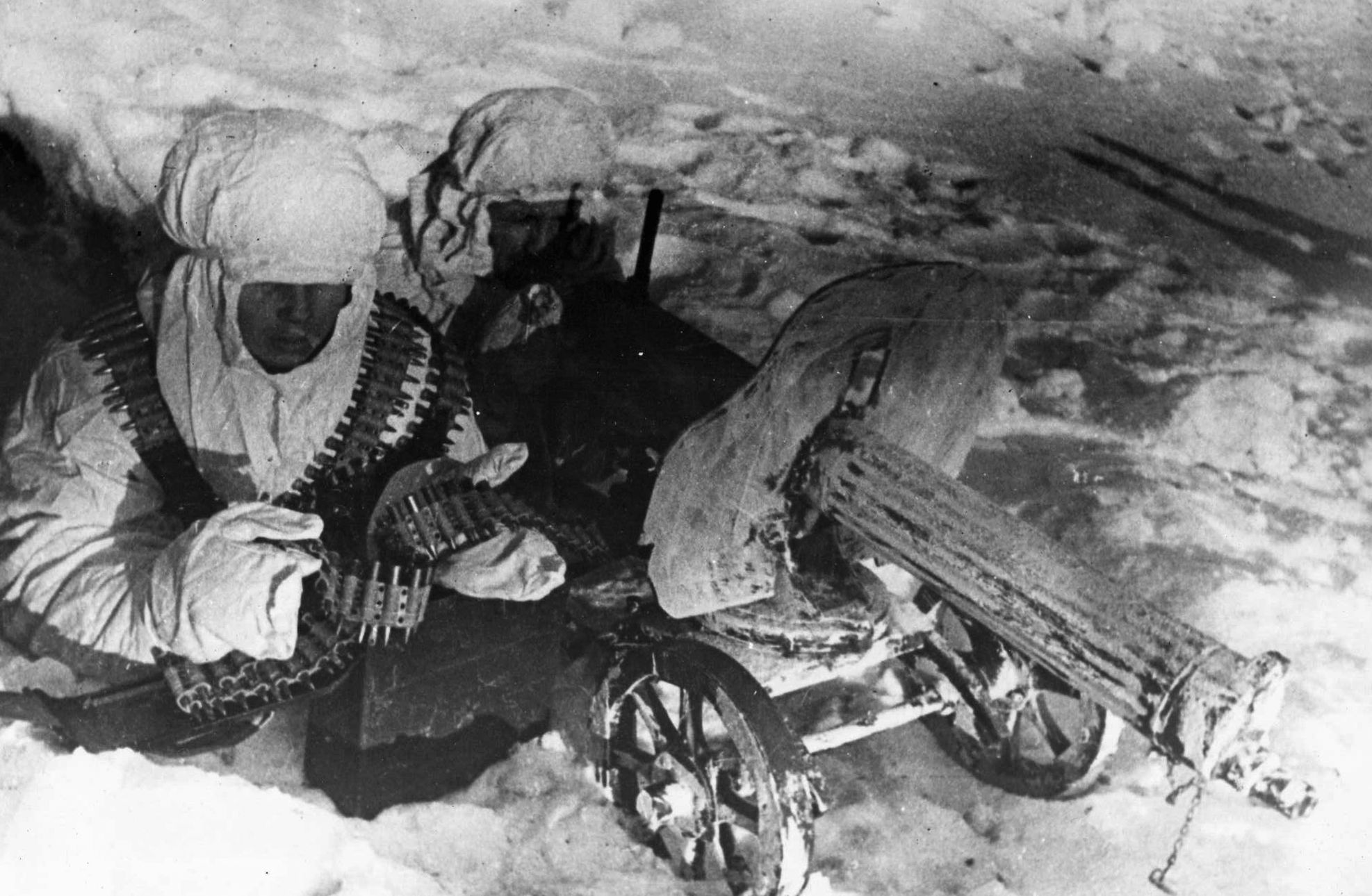 Wearing hooded camouflage uniforms, a pair of Red Army soldiers fires an antiquated machine gun at German positions. The winter weather created a no-man’s-land of snow and ice between opposing lines. 