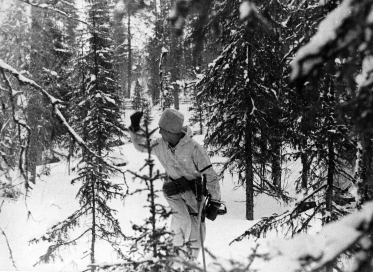 Motioning to his troops to follow quickly, a German soldier leads a detachment through a wooded area of Russia. The winter weather took a heavy toll on the unprepared Germans.