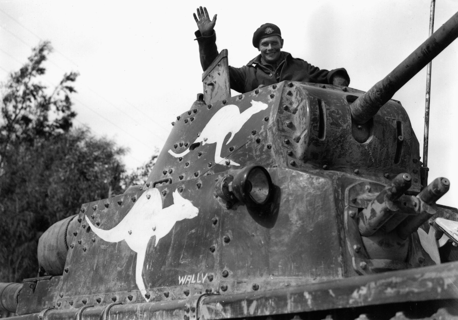 An Australian tanker waves from the turret of an Italian M13/40 light tank captured by the 6th Australian Divisional Cavalry in Cyrenaica, Libya, on March 4, 1941. The kangaroos were painted on the tank to help distinguish friend from foe. 