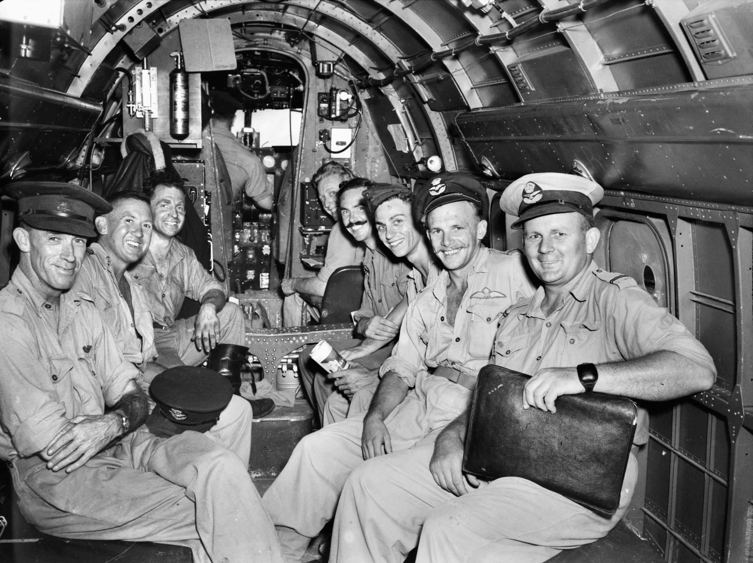 Beaming with delight at the prospect of a deserved rest, a group of RAAF men take their seats in a Lockheed Lodestar of the 37th Squadron on a flight from Noemfoor to Australia.