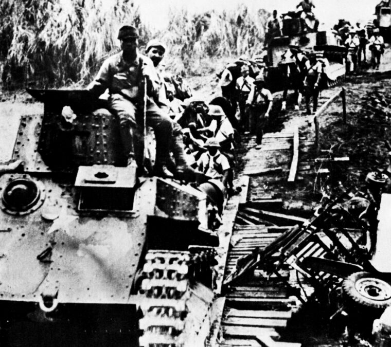 In a rare photo that includes Japanese armored vehicles, victorious infantrymen cross a makeshift bridge during the advance through Burma. The Japanese capture of Rangoon marked a low point for the Allies in the China-Burma-India Theater. (National Archives)