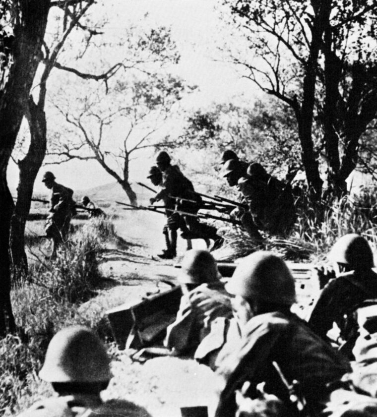 Japanese troops leap from the safety of a trench line and advance against British positions as a machine-gun crew prepares to fire in support of the charge. Such attacks, while heroic, were often repulsed with severe losses. 