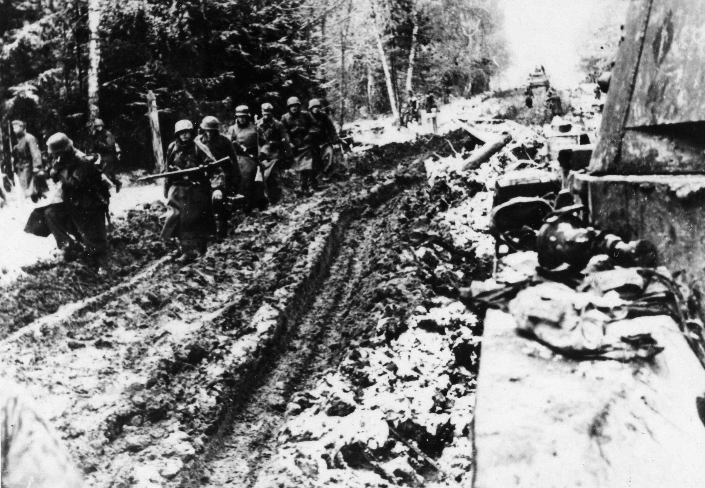 German soldiers are seen struggling to advance along a Russian road that has been turned into a sea of sticky mud by the winter thaw. German men and equipment were severely tested by the elements on the Eastern Front as well as by the Red Army.