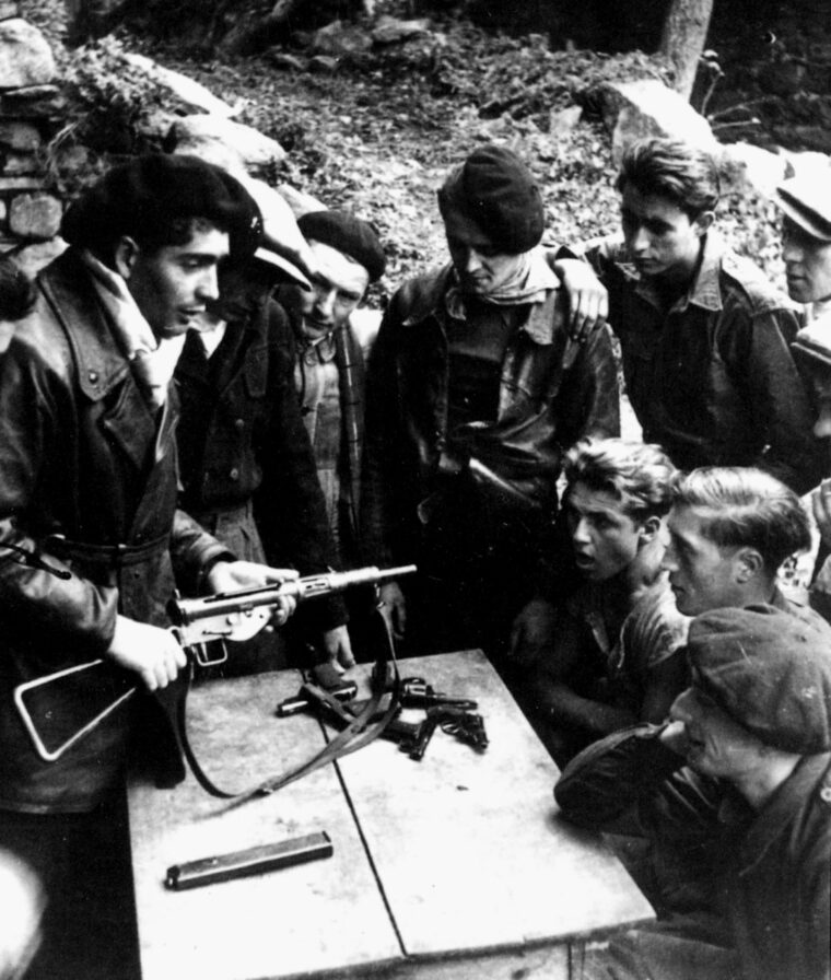 French Resistance fighters discuss plans after receiving a drop of weapons from the British. F-Section of the British SOE was mandated to aid  resistance groups across France in an effort to mislead the  Germans. (National Archives)