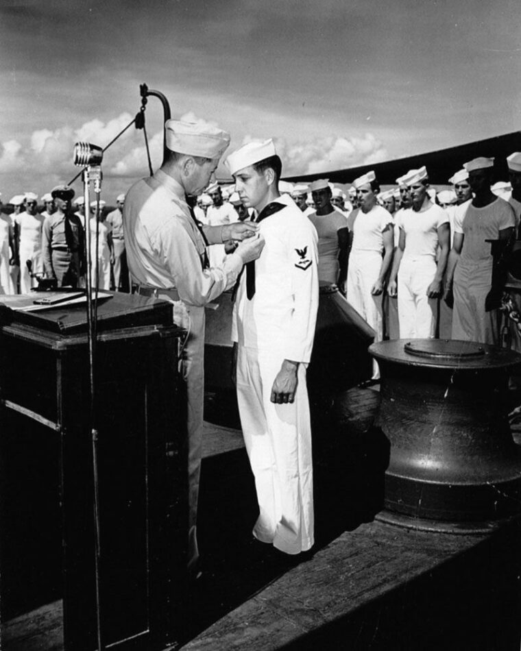 Captain Ellis Zacharias presents a Distinguished Flying Cross to Harrison D. Miller for heroism in action aboard the battleship USS New Mexico.