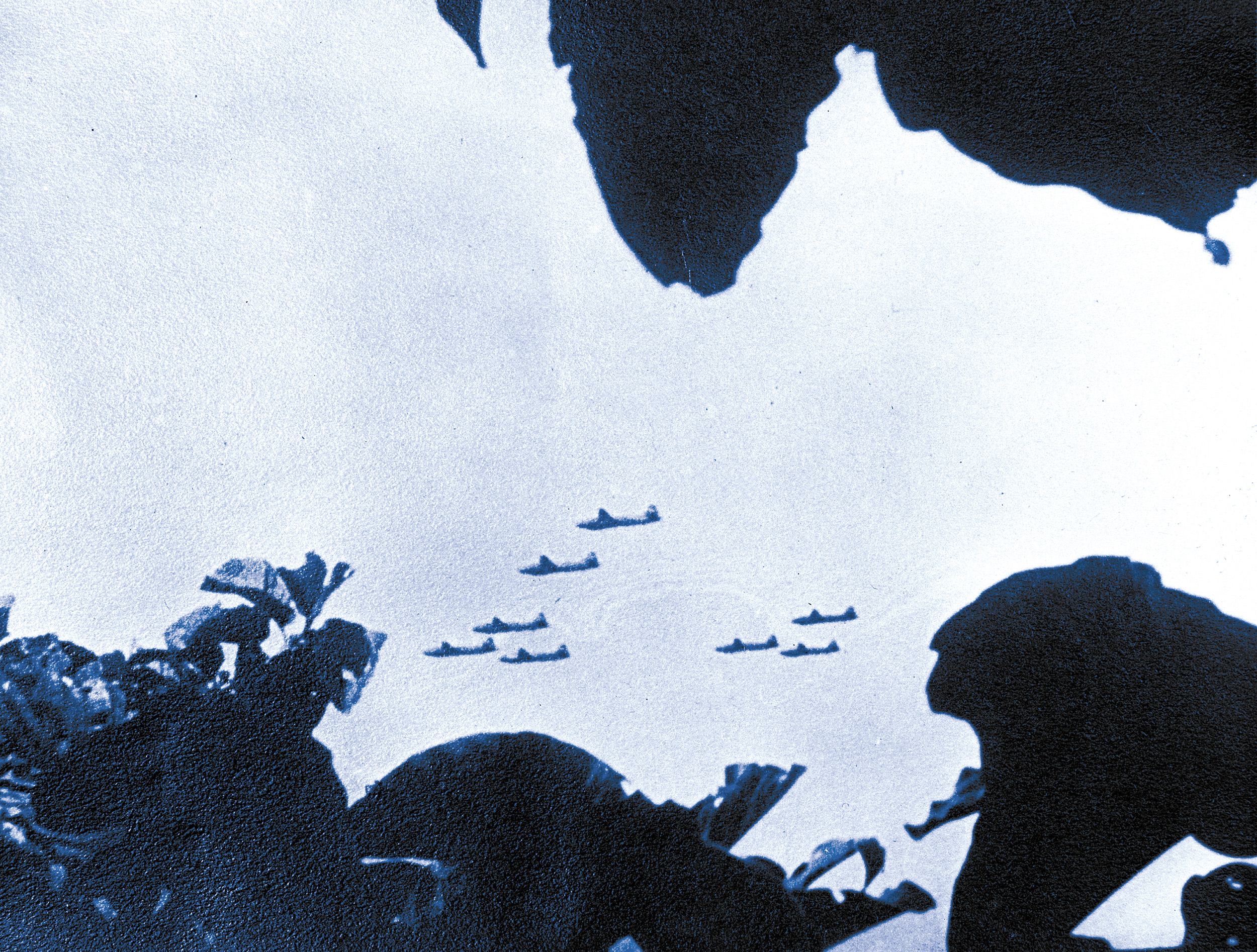In a 1943 photo possibly taken by a coast watcher, a formation of Japanese Mitsubishi Betty bombers wings its way over New Guinea toward a distant target. 