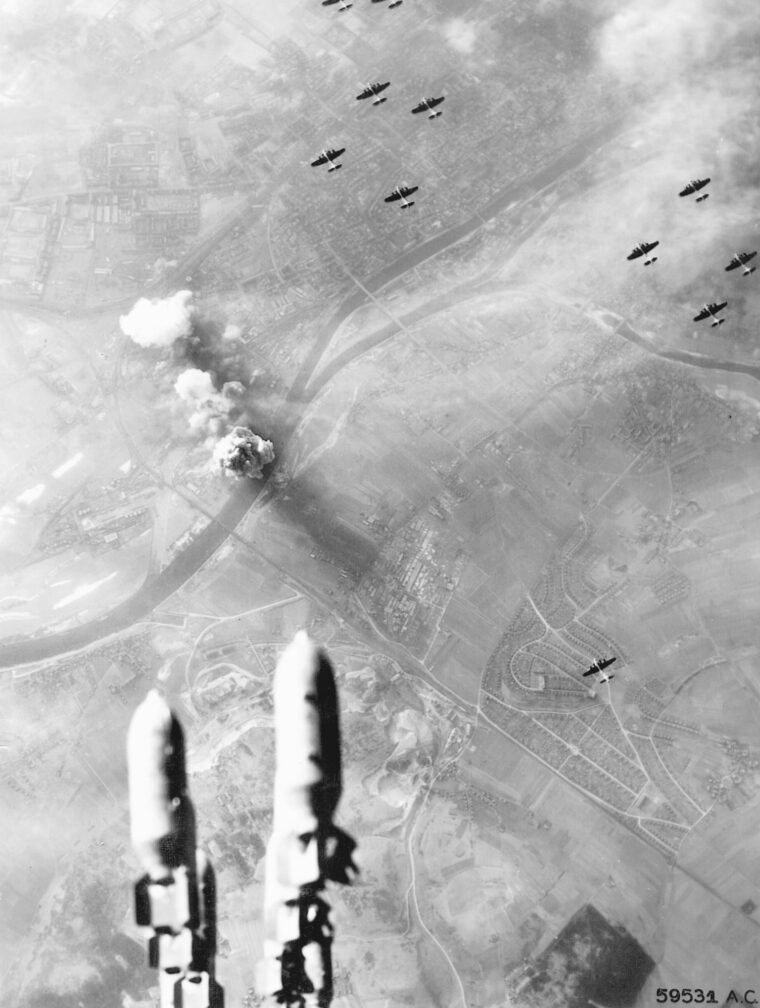 In a view from the bomb bay of a B-17, the plane’s bombs fall on the German city of Regensburg. American bombers suffered heavy losses in the daylight raid on the industrial center deep inside Germany.