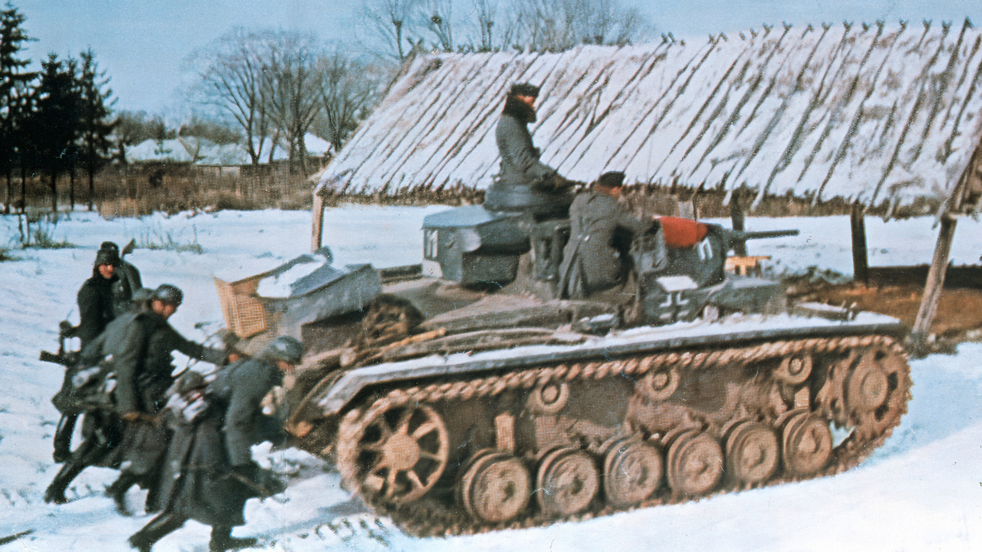 German soldiers and tanks on the offensive in Russia during the winter of 1942 move across the snowy landscape of a Russian village. This photo first appeared in Signal, a magazine published for members of the German military.