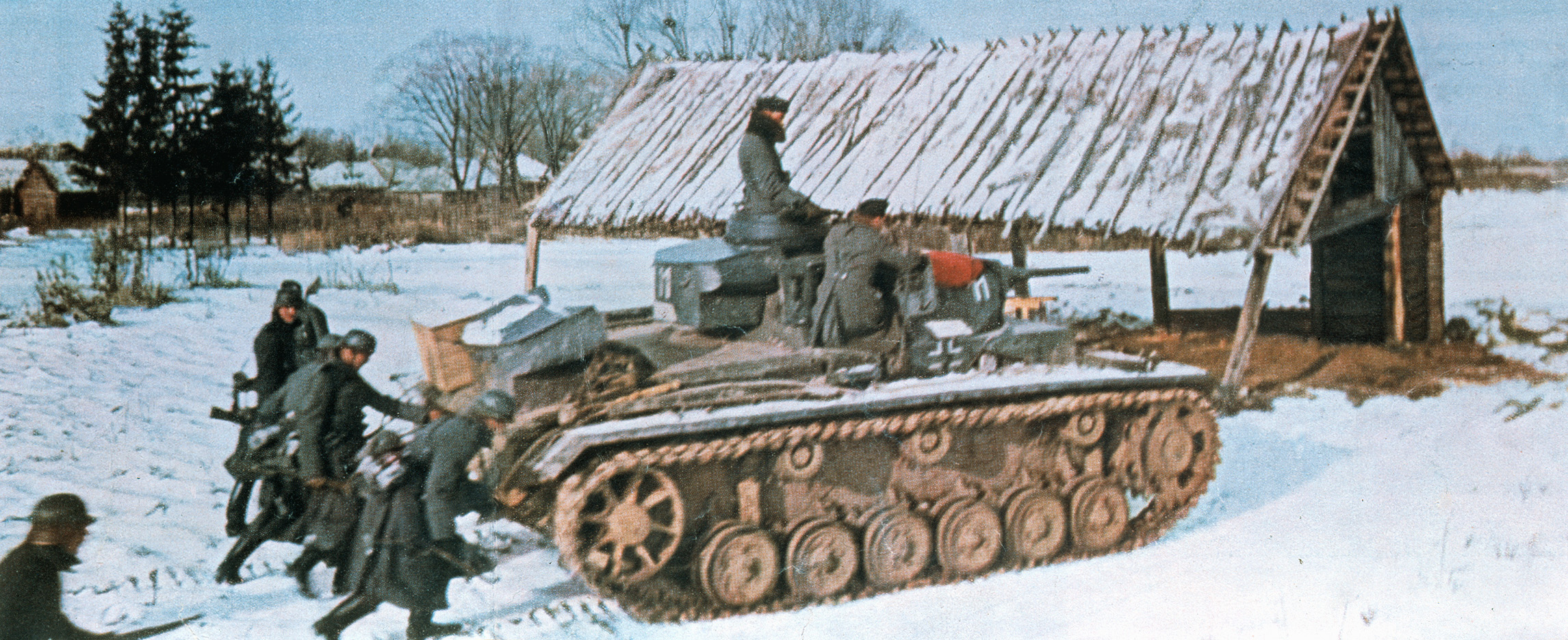 German soldiers and tanks on the offensive in Russia during the winter of 1942 move across the snowy landscape of a Russian village. This photo first appeared in Signal, a magazine published for members of the German military.