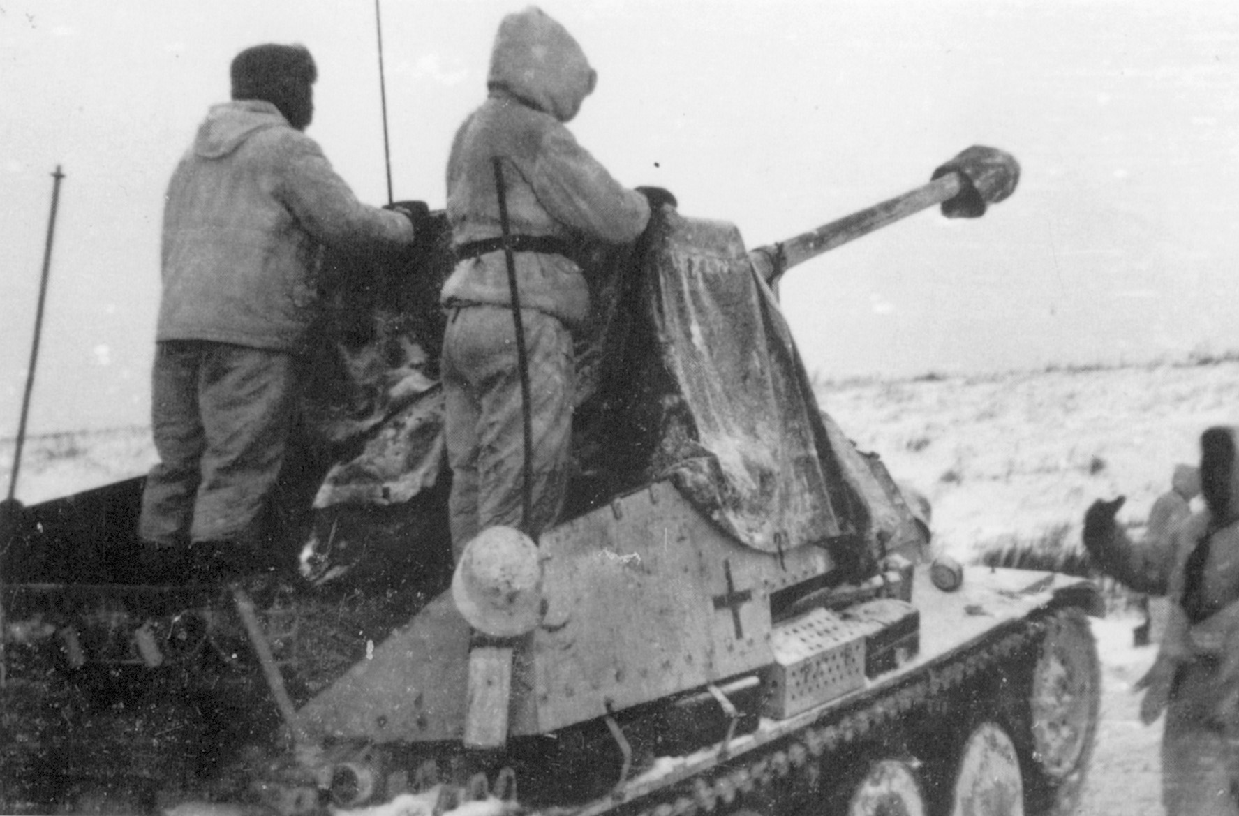 A self-propelled Sdkfz 138 assault gun of the 2nd SS Division Das Reich rolls into position during the winter of 1941 as two crewmen stare across the desolate, frozen landscape of Russia.