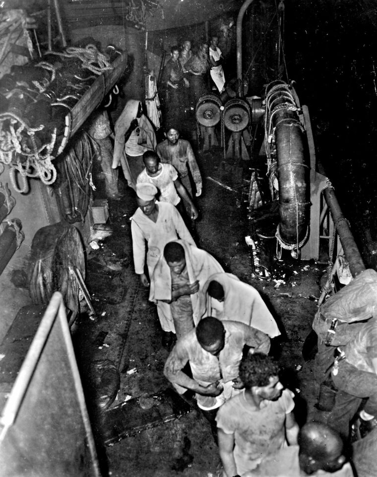 Pulled from the Pacific by sailors of the destroyer USS McCalla, men of the 855th Engineer Aviation Battalion leave the warship after it has made port. The survivors exhibit the strain of their ordeal following the sinking of the troopship SS Cape San Juan.