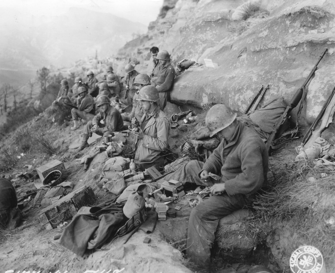During combat operations in Italy in October 1944, soldiers of the 91st Infantry Division rest against a rocky outcropping and eat K Rations. The K Ration was relatively easy to transport, and it was alternately loved and hated by GIs the world over.
