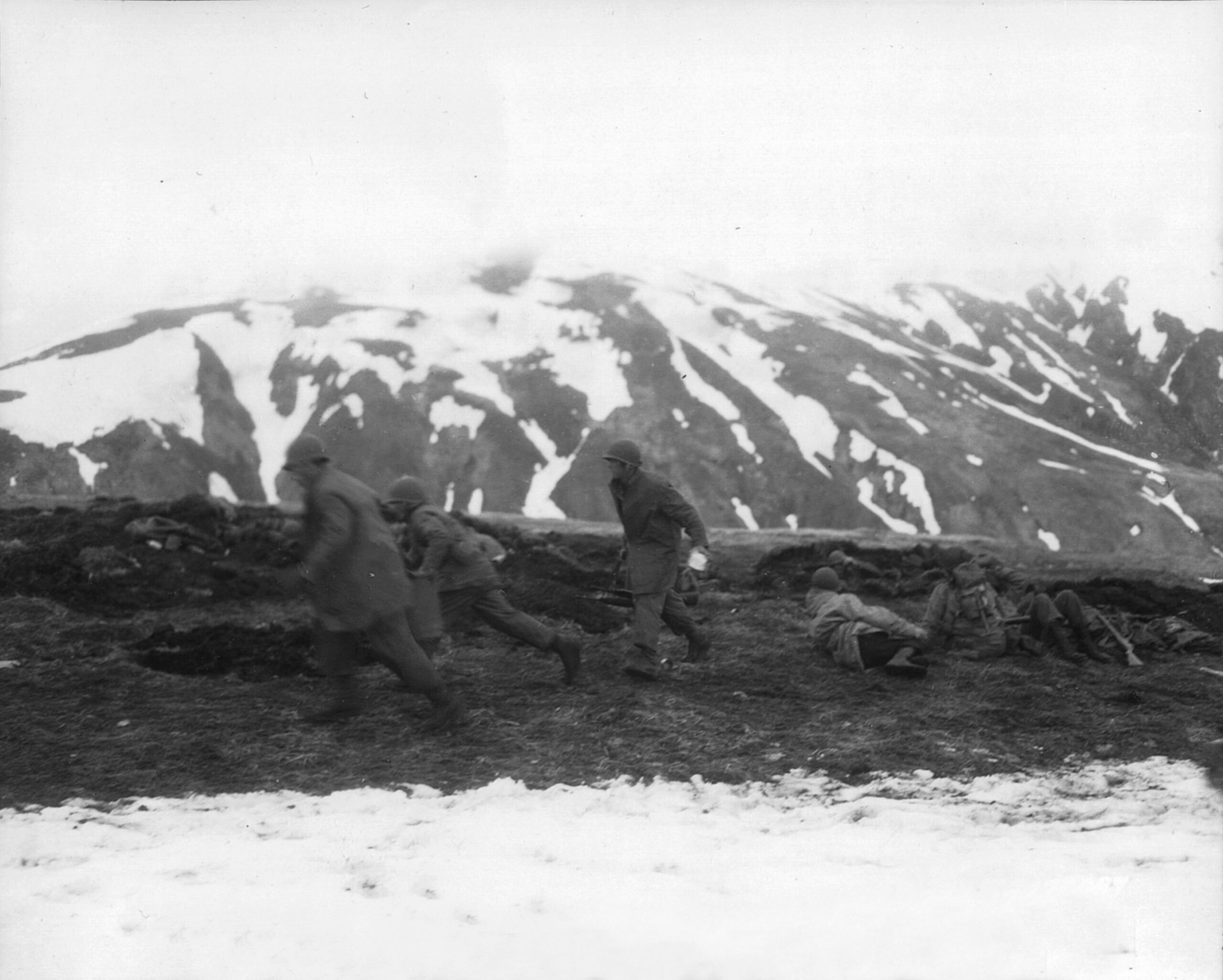 U.S. soldiers hustle hot food to troops manning the perimeter on Attu in May 1943. Hot food was considered a luxury in most combat areas.