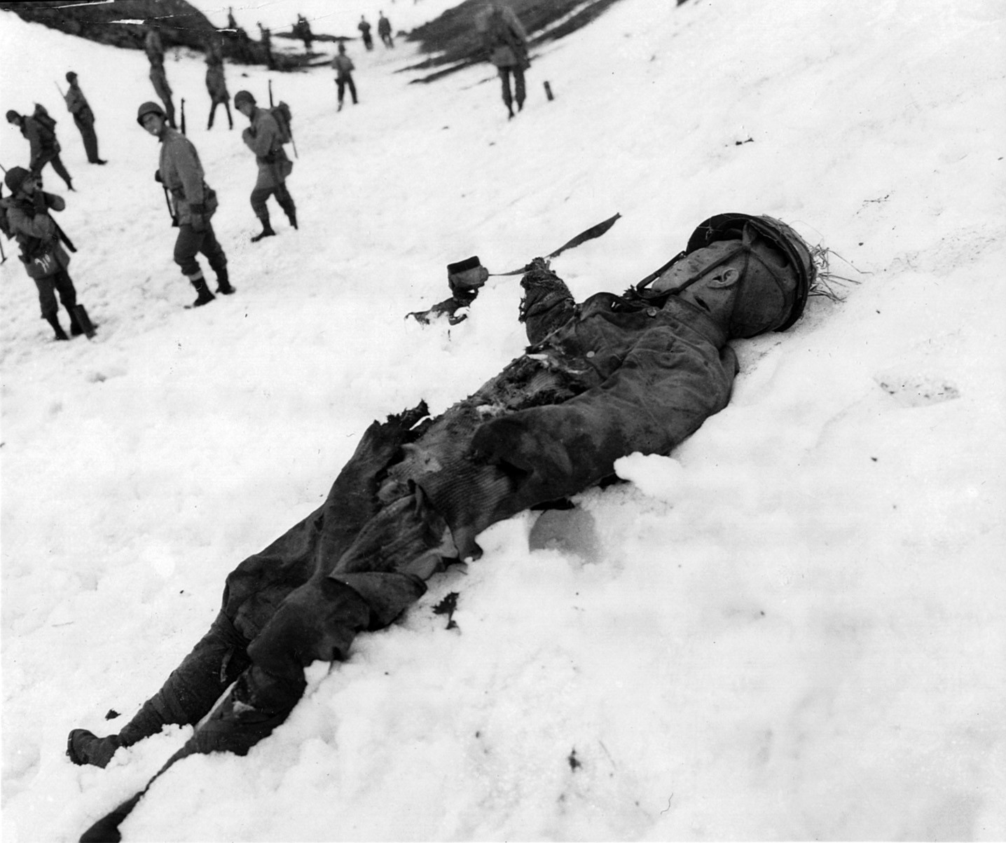 Lying dead in the snow, the body of a Japanese soldier killed in action at Holtz Bay on Attu awaits a burial detail.