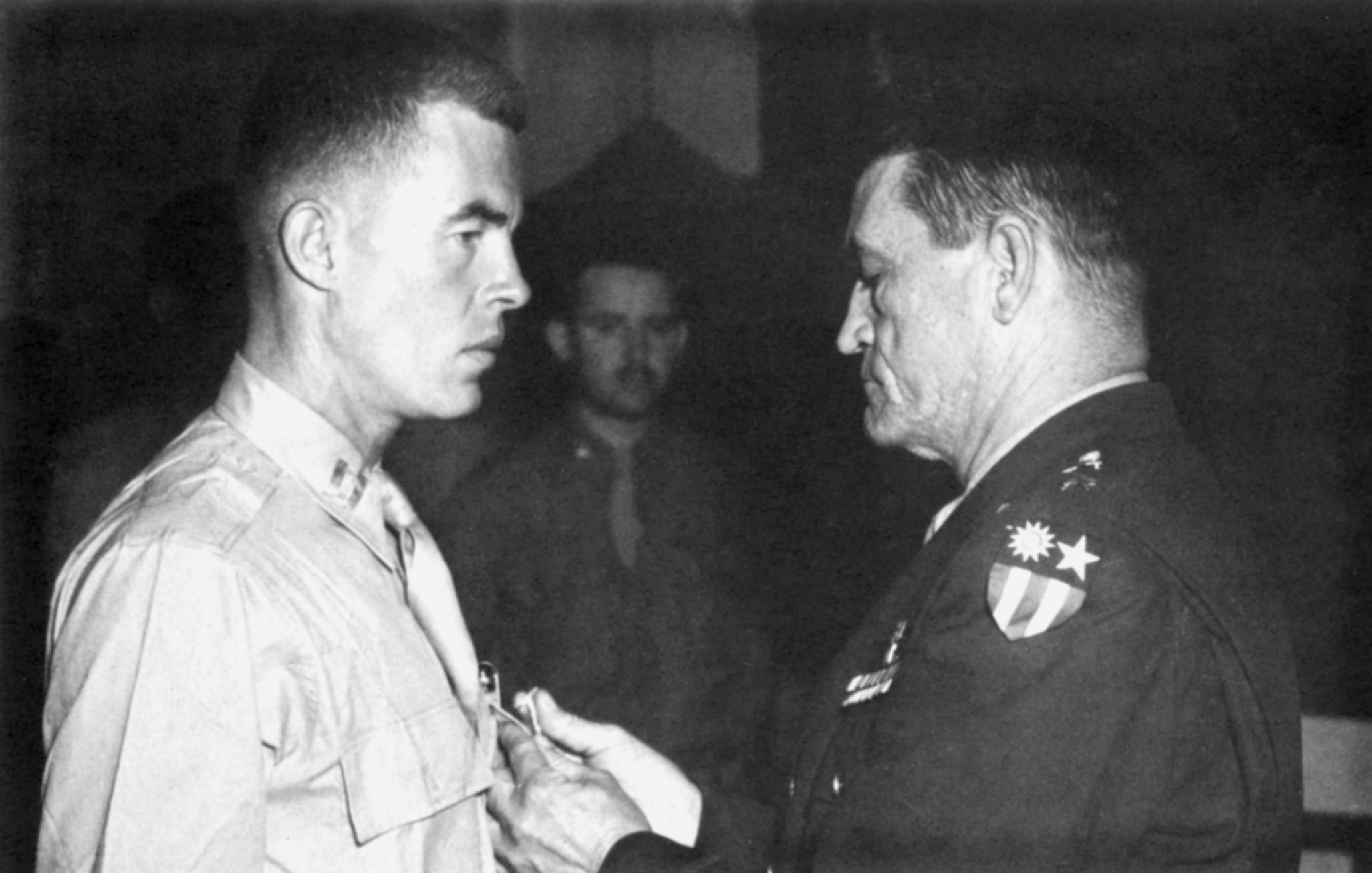 Recognizing Lieutenant John Birch for his  bravery in undertaking hazardous missions behind Japanese lines in China, General Claire Chennault, commander of the U.S. Fourteenth Air Force, pins a medal on the hero’s chest. 