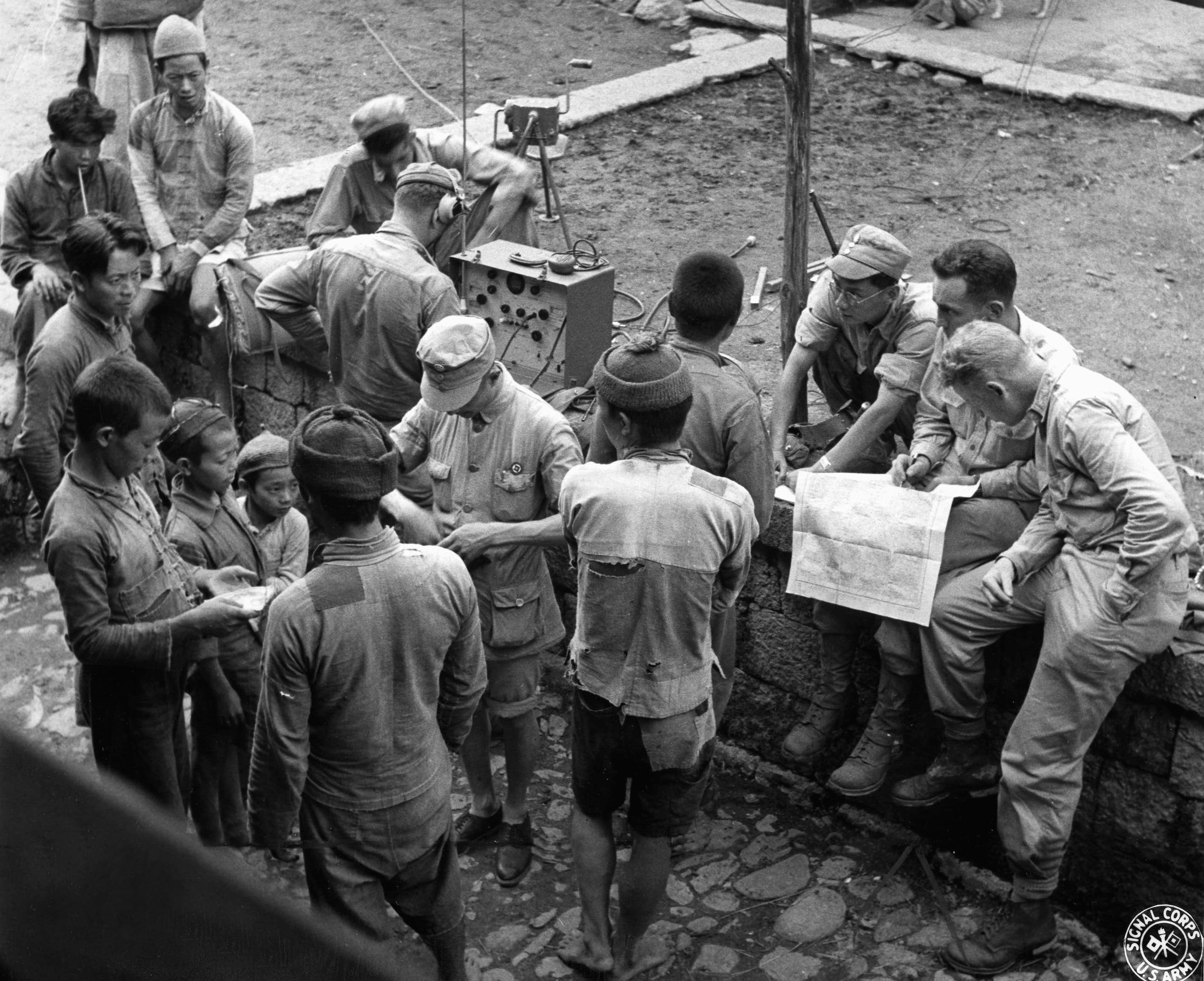 Questioning a local villager as to their position, members of Y Force stop in a remote Chinese village for the night. Utilizing a map, they attempt to orient themselves during their foray into northern Burma and work to establish radio communications.