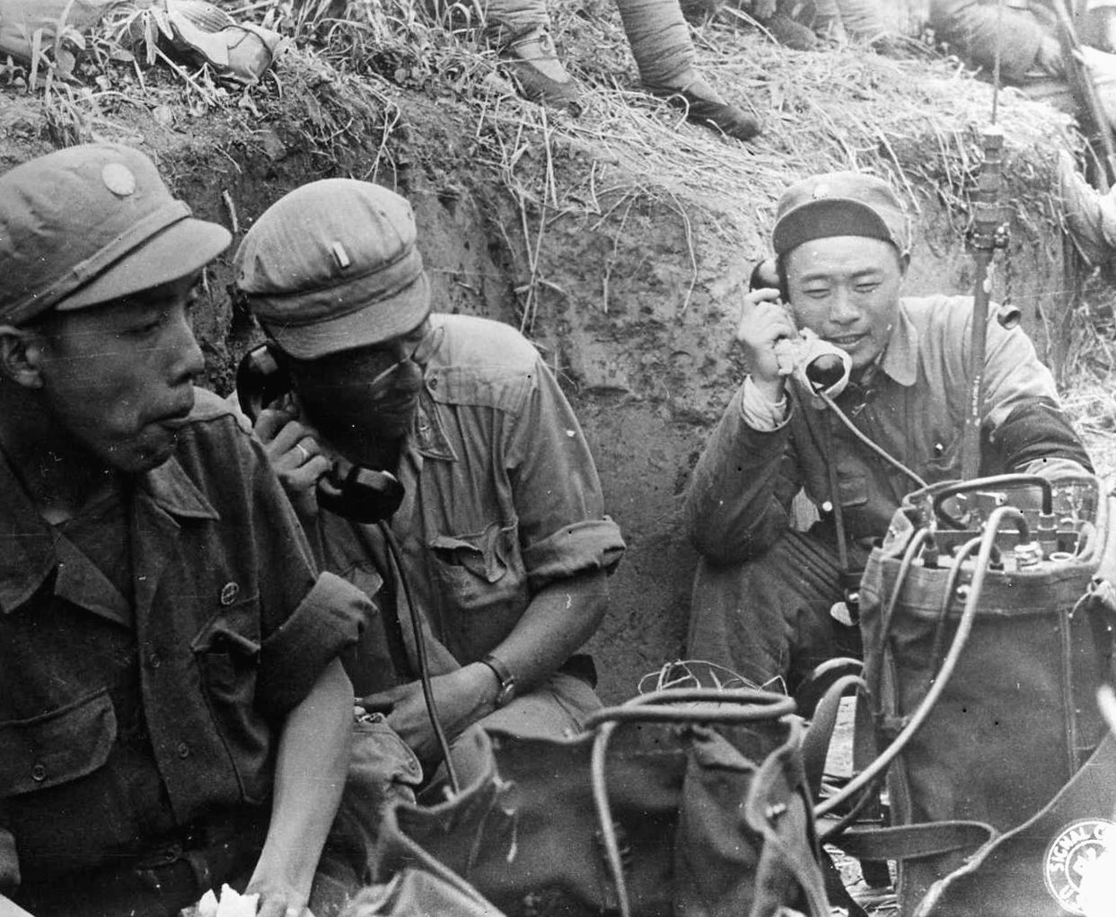 Colonel Jong, a Chinese interpreter, Lieutenant John Wylie of the 1st Tactical Communication Squadron, and Colonel Chew Fong Liang, commanding officer of the Chinese Army’s 57th Regiment, 15th Division direct the deployment of troops via field telephone.