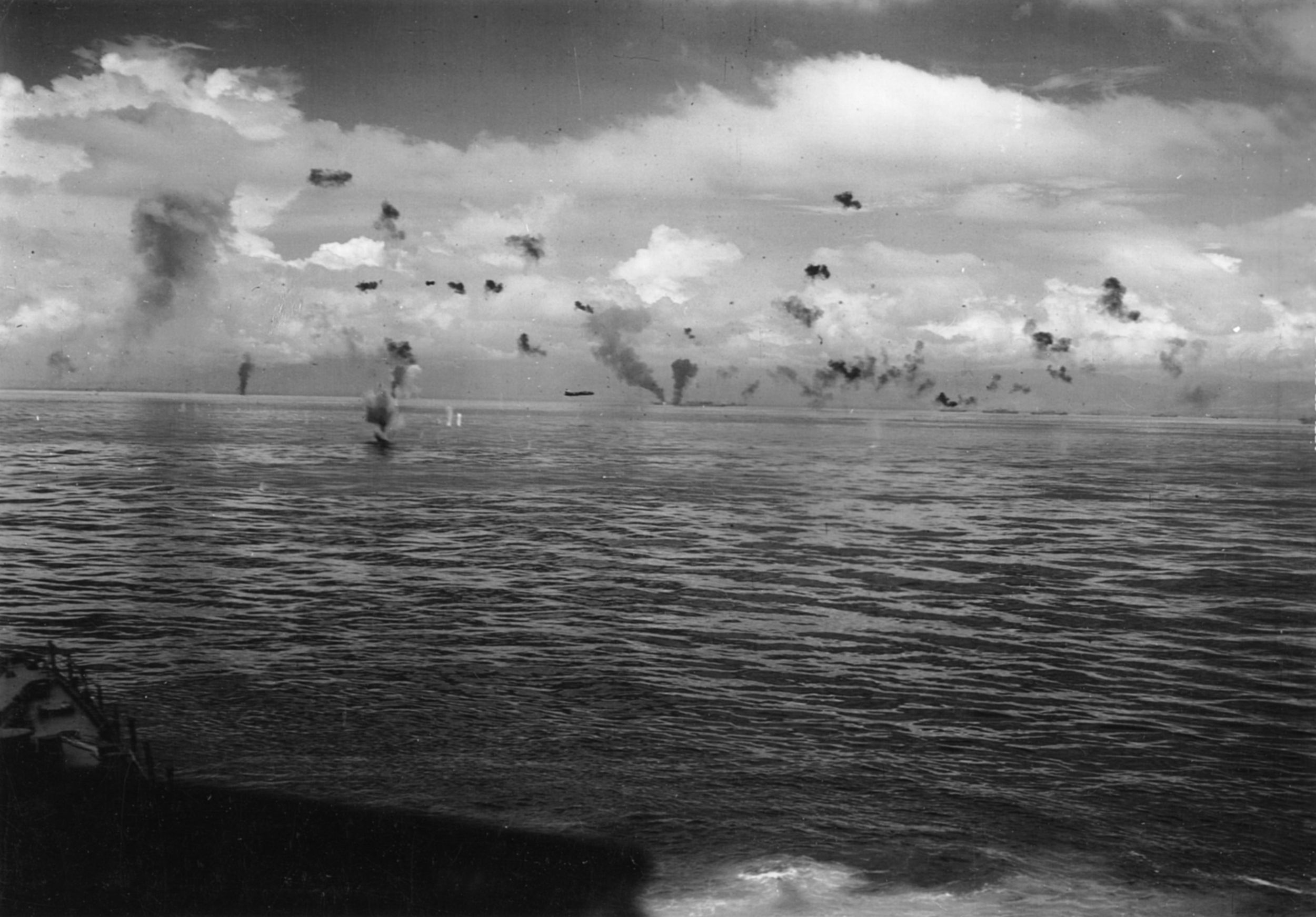 On August 8, 1942, a photographer aboard the Chicago captured this image of Japanese torpedo planes attacking American ships off of Tulagi in the Solomons. One plane streaks toward its target while two others are ablaze and antiaircraft fire dots the sky.