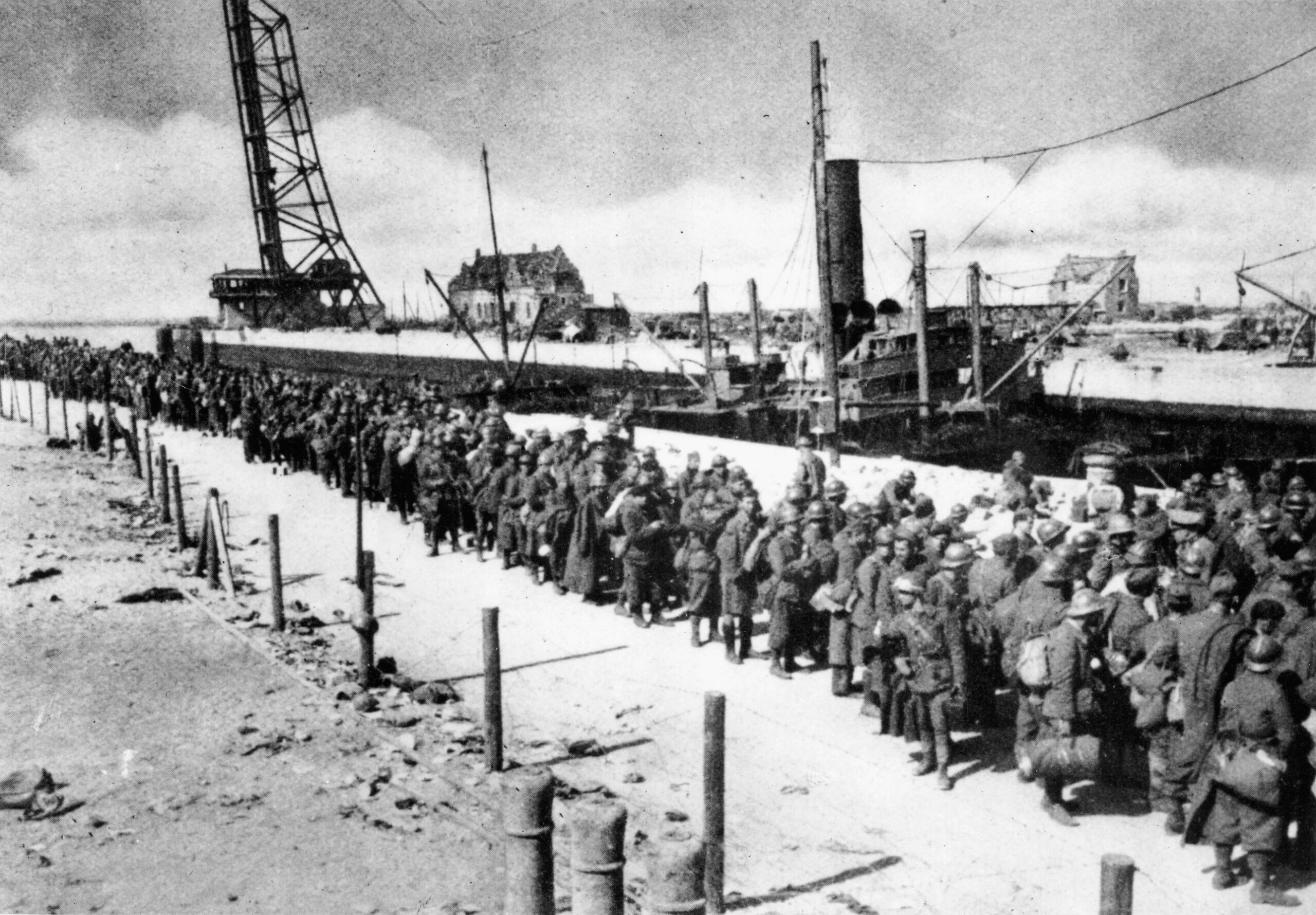 Unable to escape, a large number of British and French prisoners await instructions from their German captors on a now quiet Dunkirk beach. 