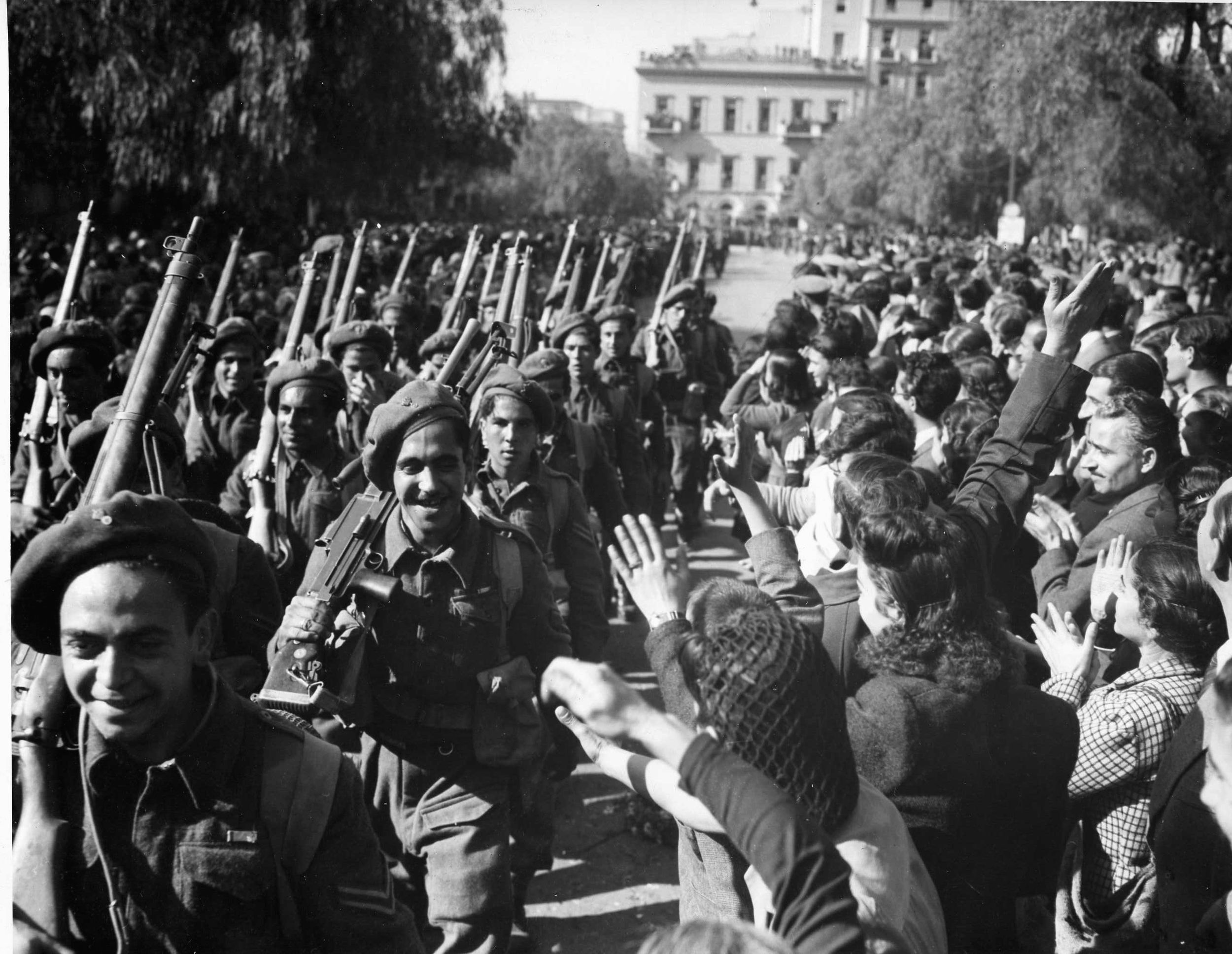 Shortly after their arrival in their native country from Italy, soldiers of the Greek Mountain Brigade receive a hero’s welcome as they parade through the streets of Athens. 