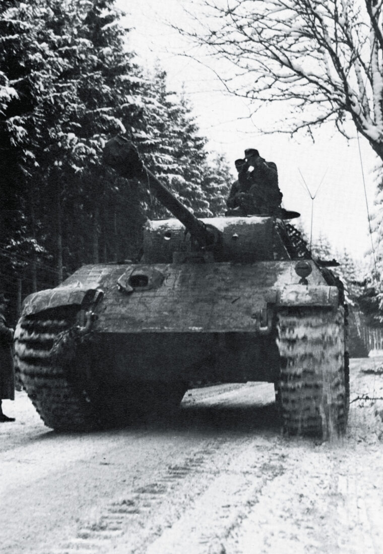 Its commander riding in the open air for better visibility, a German panzer rolls into Belgium in December 1944.
