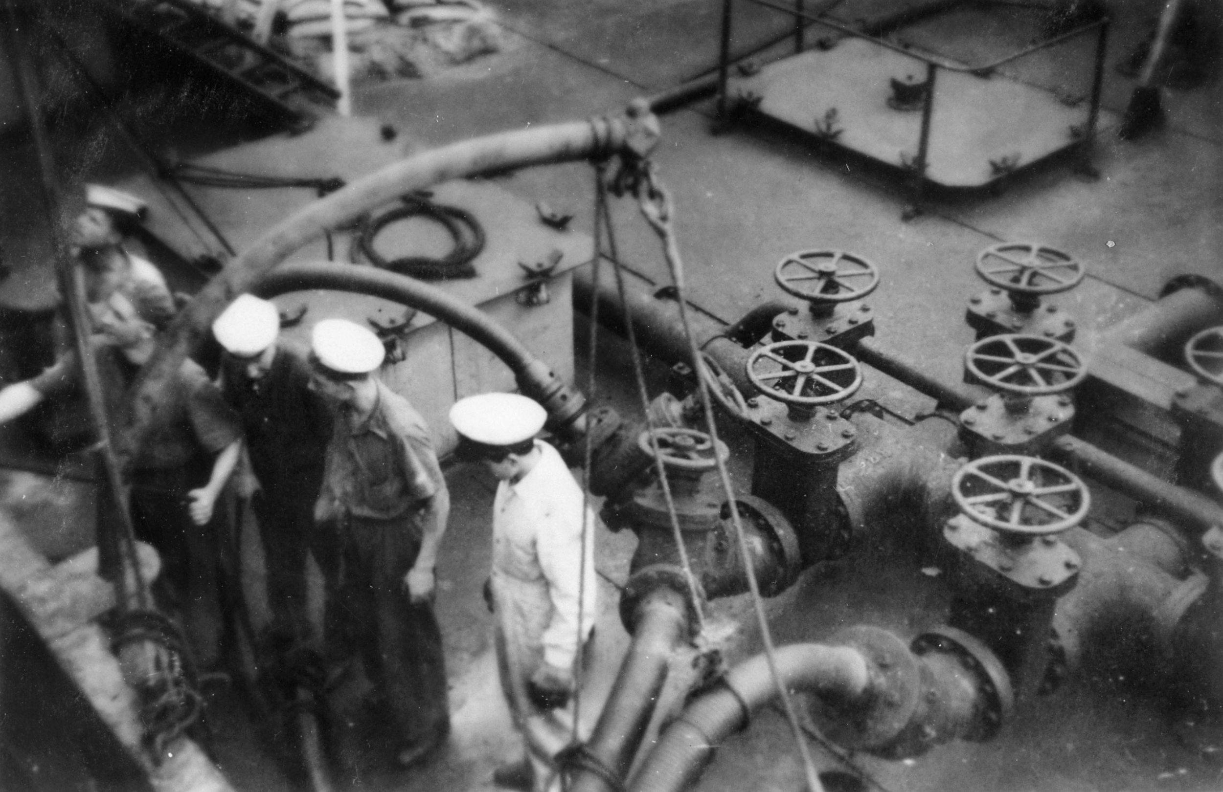 Hours before the Battle of Cape Matapan, crewmen aboard the Australian cruiser HMAS Perth take part in a refueling operation.