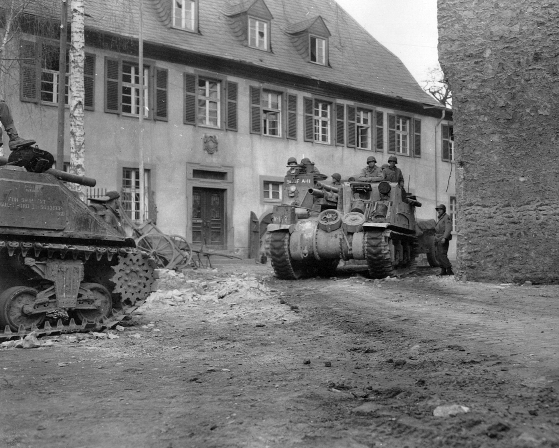 Tanks of the 9th Armored Division roll through an abandoned French village. During the defense of St. Vith, the 9th Armored and several other American units suffered heavy casualties.