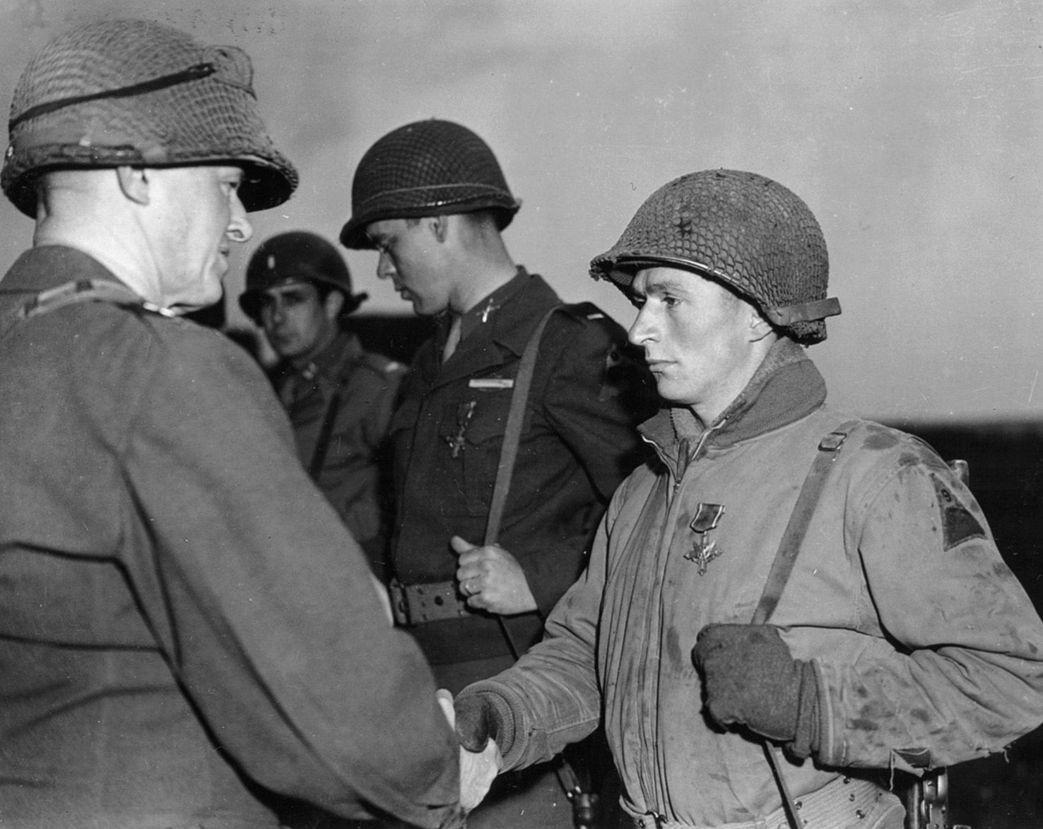 For heroism in action at St. Vith, Technical Sergeant Michael Chincher of the 9th Armored Division receives the Distinguished Service Cross from Maj. Gen. John W. Leonard, the division commander, on April 11, 1945.