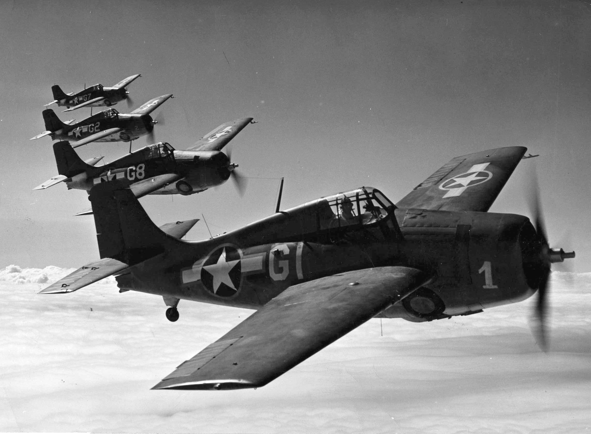 A formation of Grumman F4F Wildcat fighter planes banks slowly to the right. Wildcats flown by U.S. Marine Corps aviators based at Henderson Field on Guadalcanal were instrumental in maintaining daylight air superiority and securing the island. (National Archives)