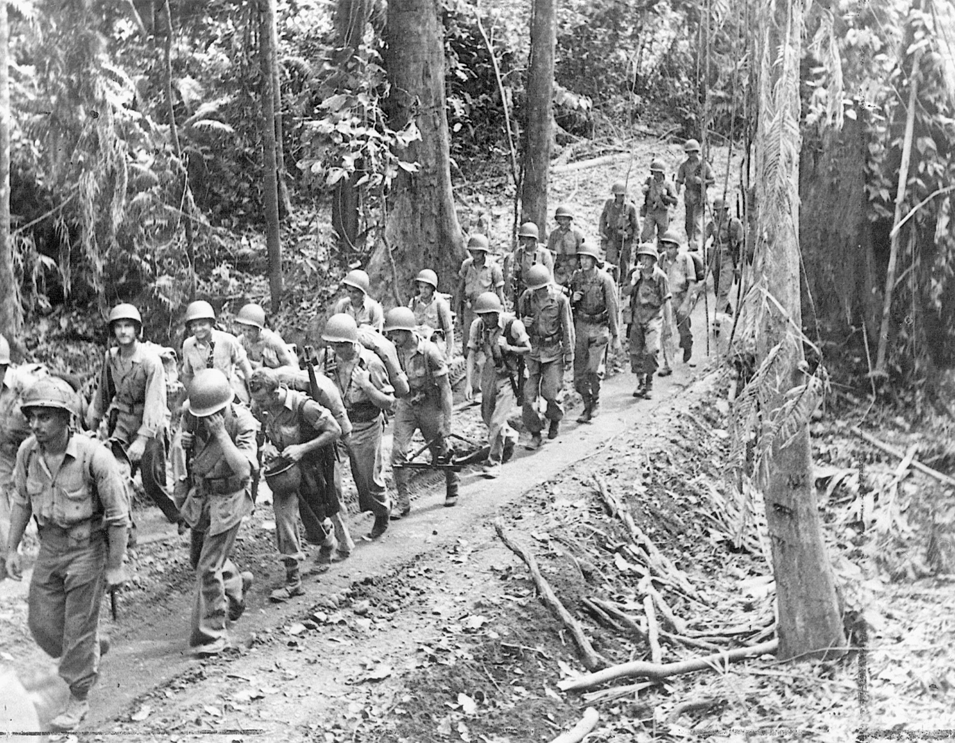 Advancing Marines move through dense jungle on their way to new positions on Guadalcanal.