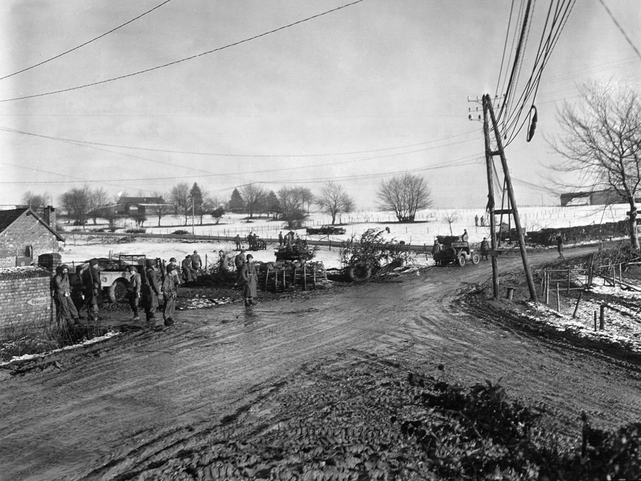 Standing watch at a crossroads near Malmédy, U.S. troops wait for the inevitable clash with the Germans.