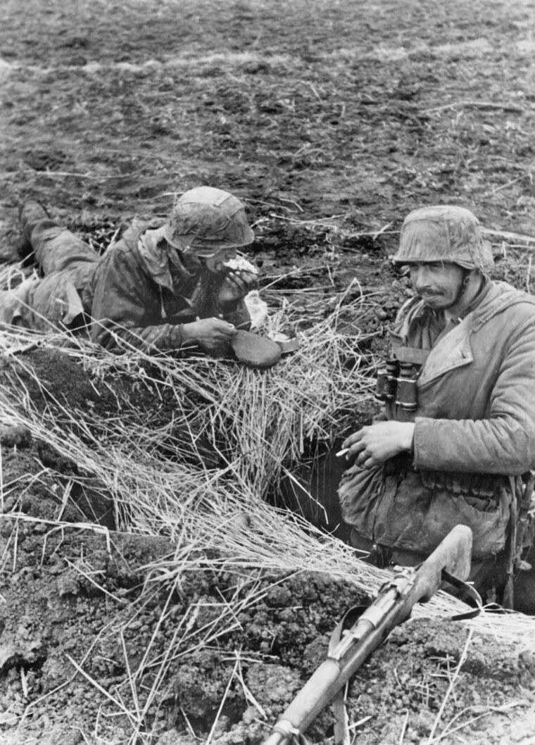 During a welcome lull in the fighting on the Eastern Front, two German soldiers take time to eat a quick meal and smoke cigarettes. Such moments were few for the beleaguered German defenders at Ternopil.