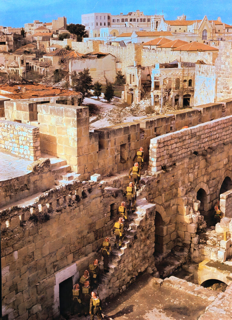Arab Legion soldiers move through the ruins of Jerusalem during the Arab-Israeli War of 1948-1949. Hand-to-hand fighting took place in the Old Jewish Quarter of the city.