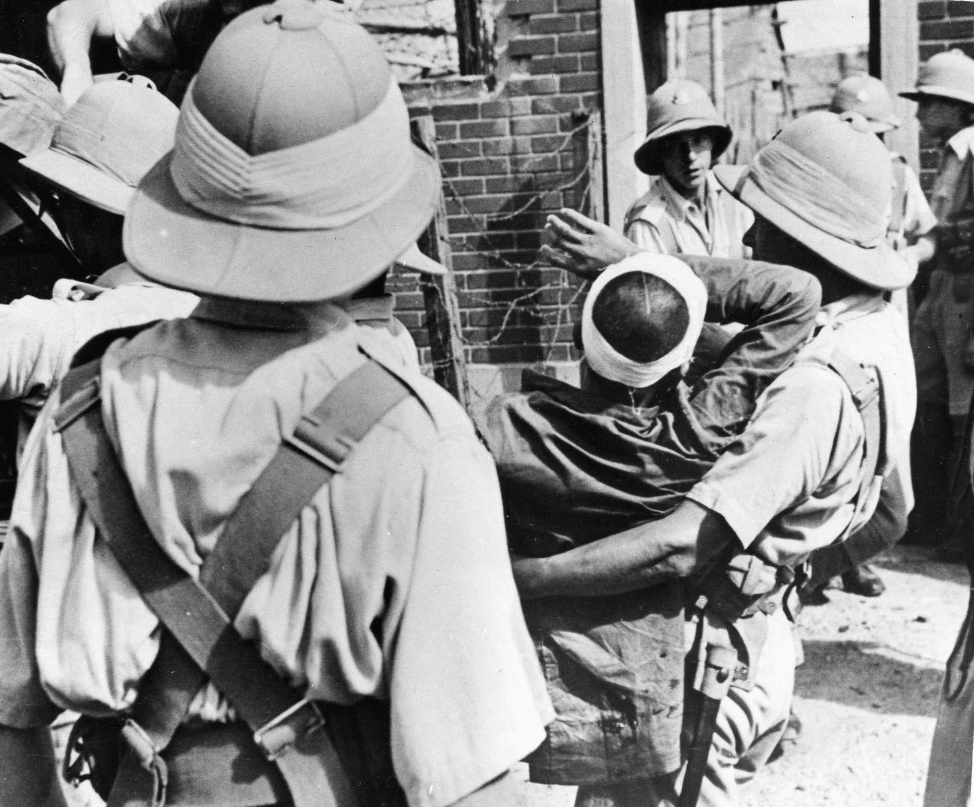A wounded member of the “Lost Battalion” is carried to an ambulance after the fighting at Sihang Warehouse. 