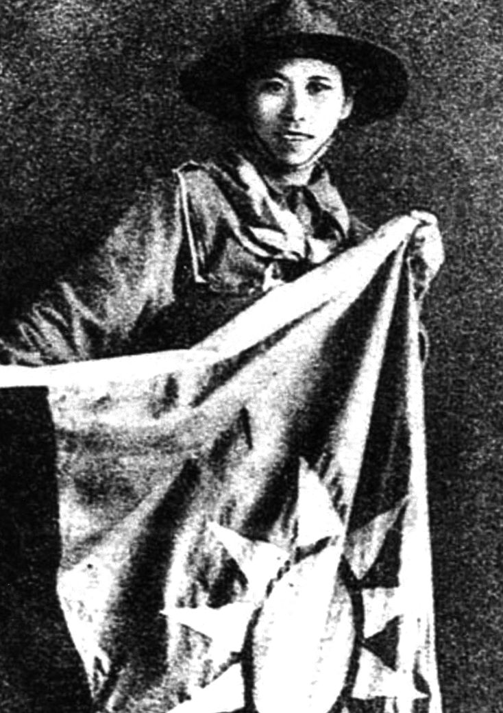 Girl guide Yang Huimin holds the flag she brought to the besieged garrison inside the warehouse.