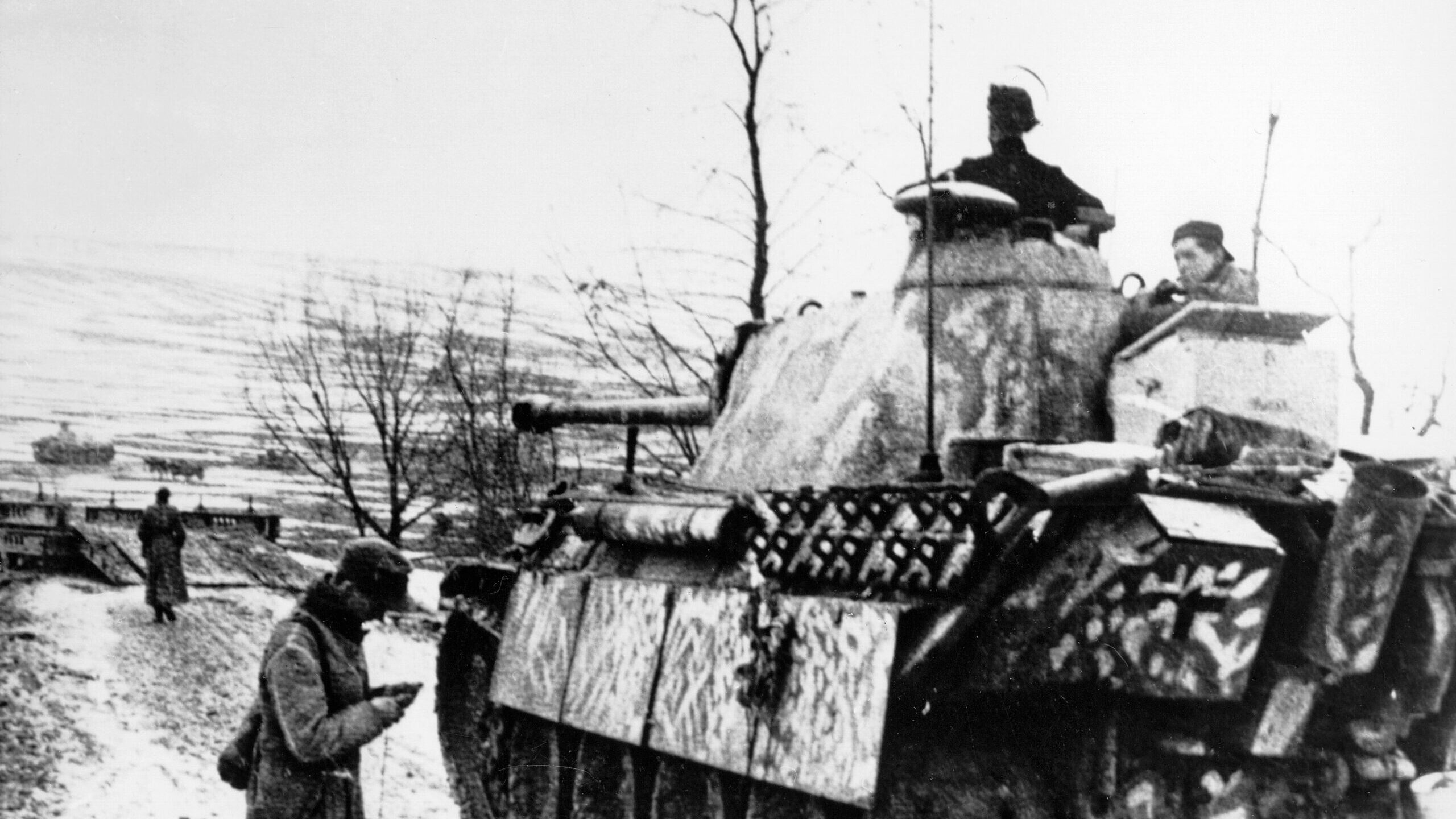 A Panther tank of the 1st SS Panzer Division “Leibstandarte” moves forward warily during the Battle of the Bulge as its commander scans the horizon for signs of enemy forces.