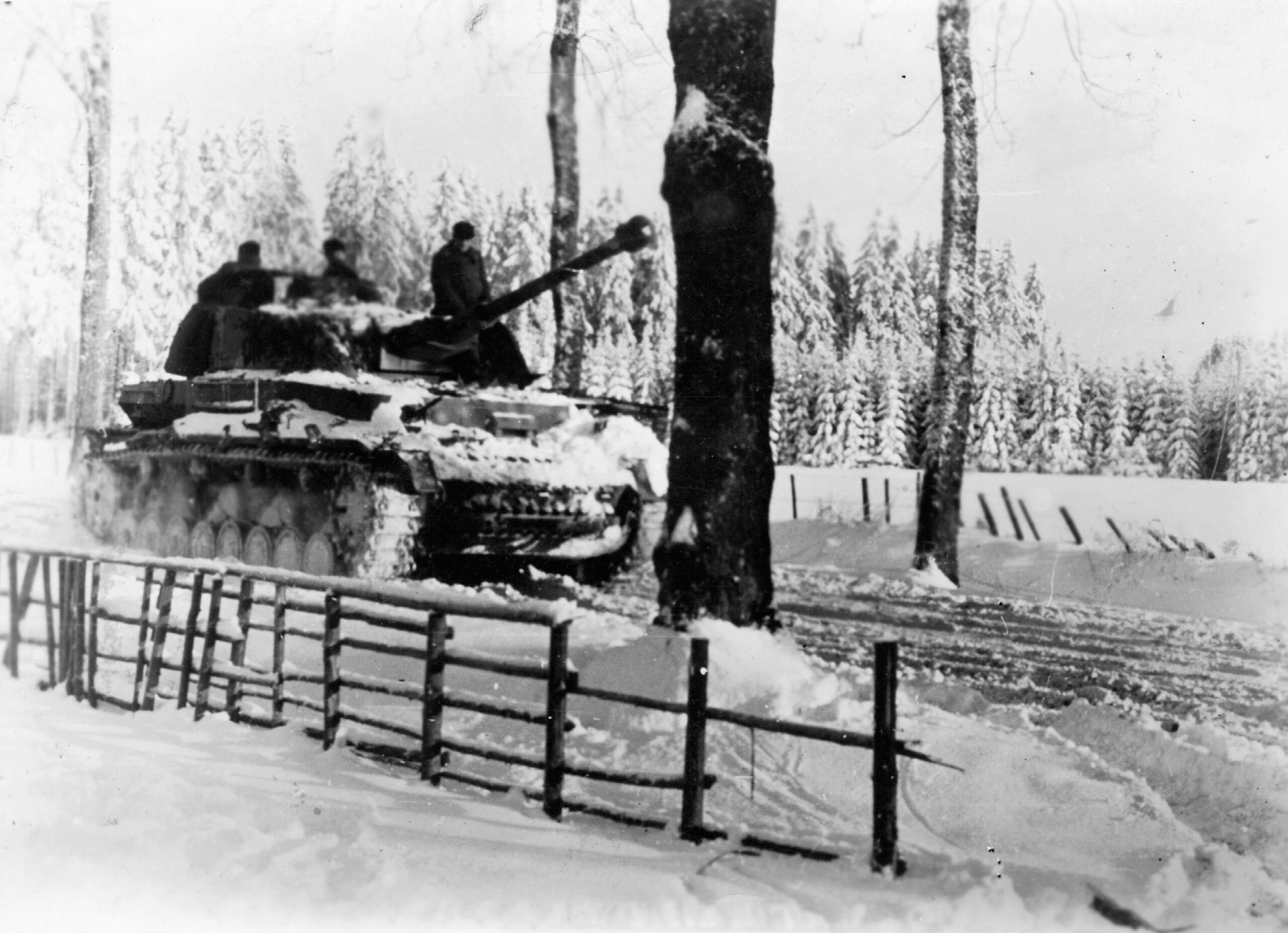A Waffen-SS Panzer IV tank rolls forward along a snow-covered road during the Battle of the Bulge.  By January 1945, the last desperate German offensive in the West had lost its momentum.